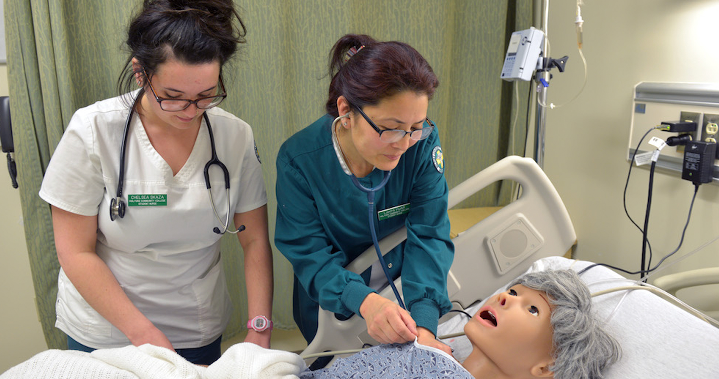 Two health students work with a patient simulator
